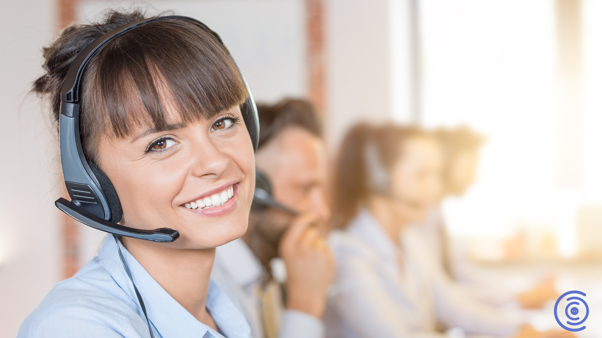 Support agent with headset at desk, smiling